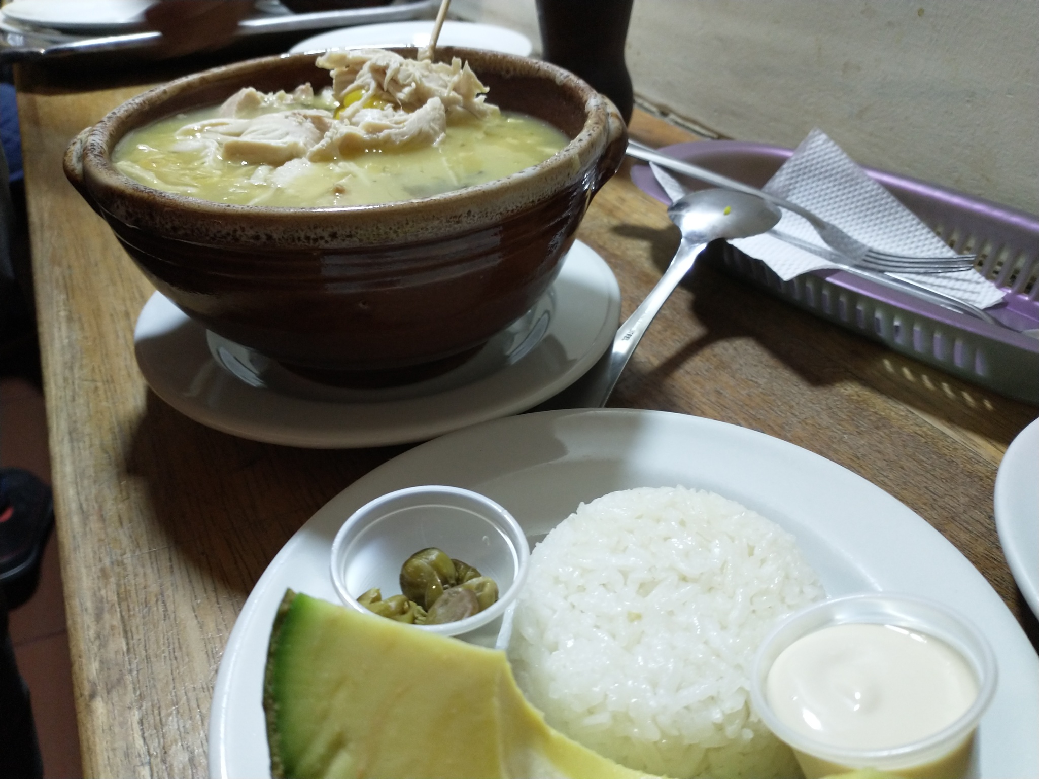 Chicken and corn soup with avocado and white rice from La Puerta Falsa.